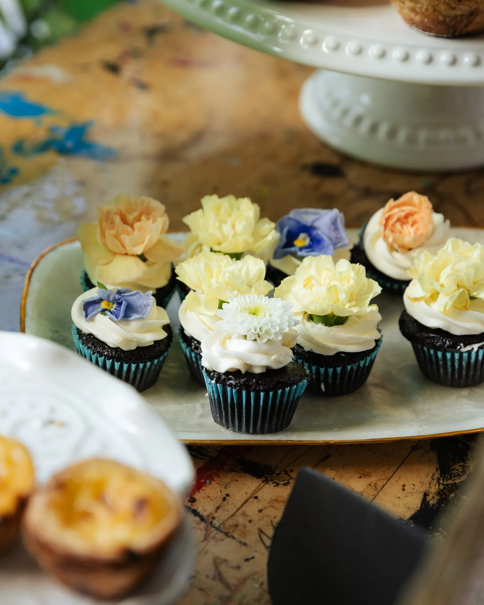 Chocolate cupcakes topped with buttercream carnations and violas